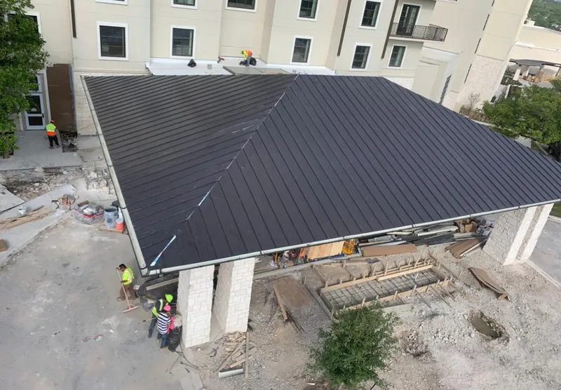 Metal roofing installation team working on a commercial building in Ogden